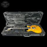 Yellow electric guitar in a black case with 'Tone Shop' logo.