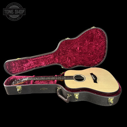Acoustic guitar in a red-lined case with 'Tone Shop' logo.