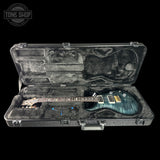 Guitar in an open case with 'Tone Shop' logo in the corner