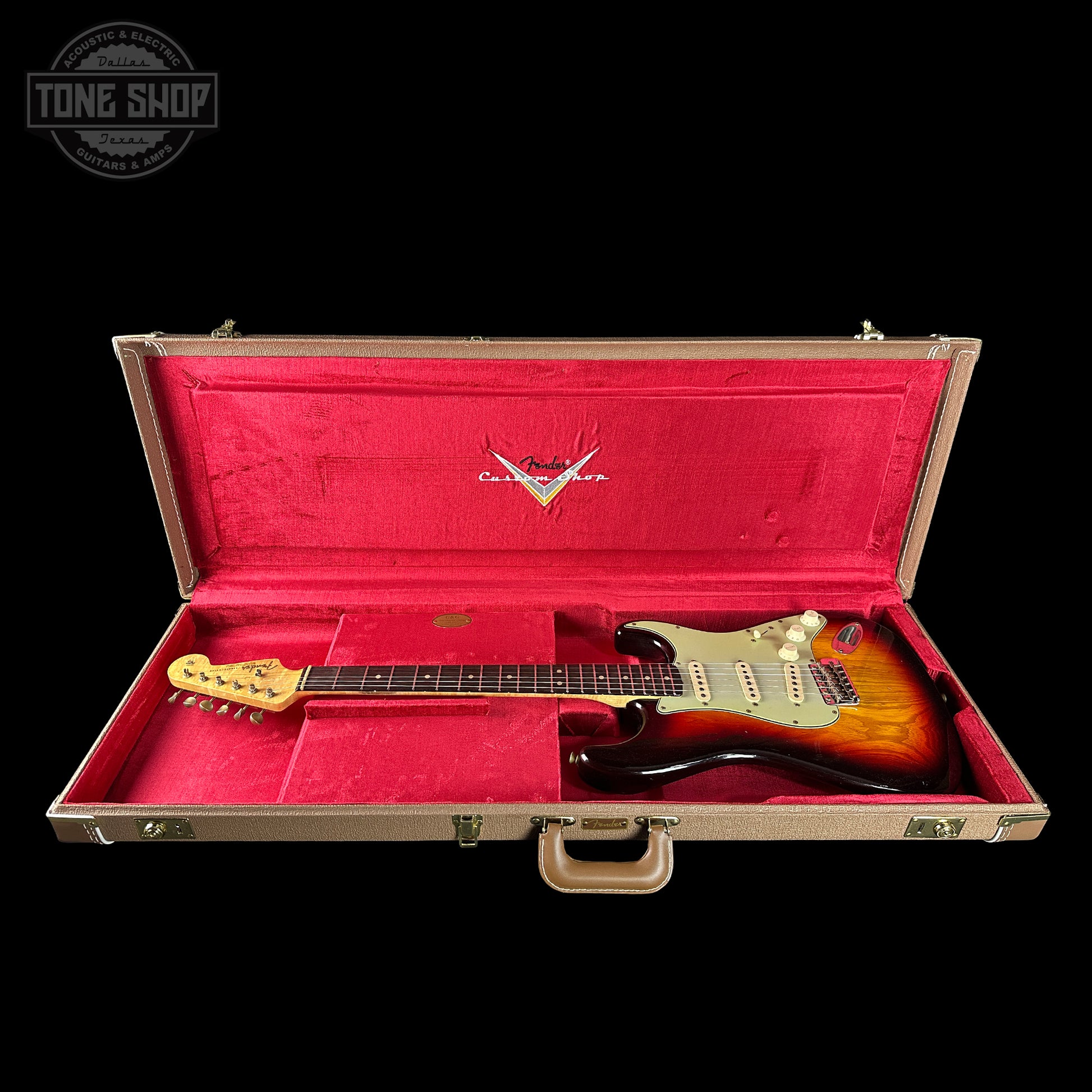 Gibson guitar in a red-lined case with 'Tone Shop' logo.