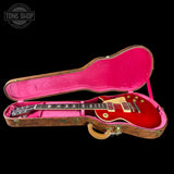 Red electric guitar in a pink case with 'Tone Shop' logo.