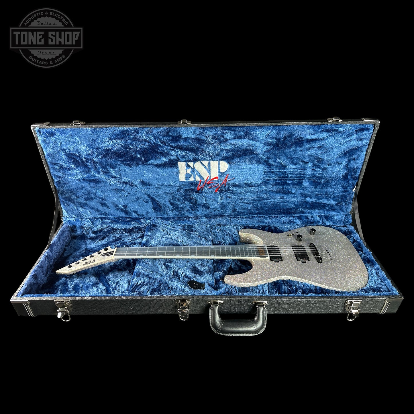 ESP electric guitar in a blue-lined case with 'Tone Shop' logo.