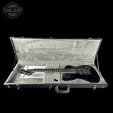 Black electric guitar in an open hard-shell case with 'Tone Shop' logo.