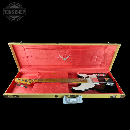 Electric bass guitar in a red-lined case with a visible brand logo on a black background.