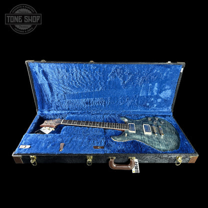 Guitar in an open blue case with 'Tone Shop' logo.