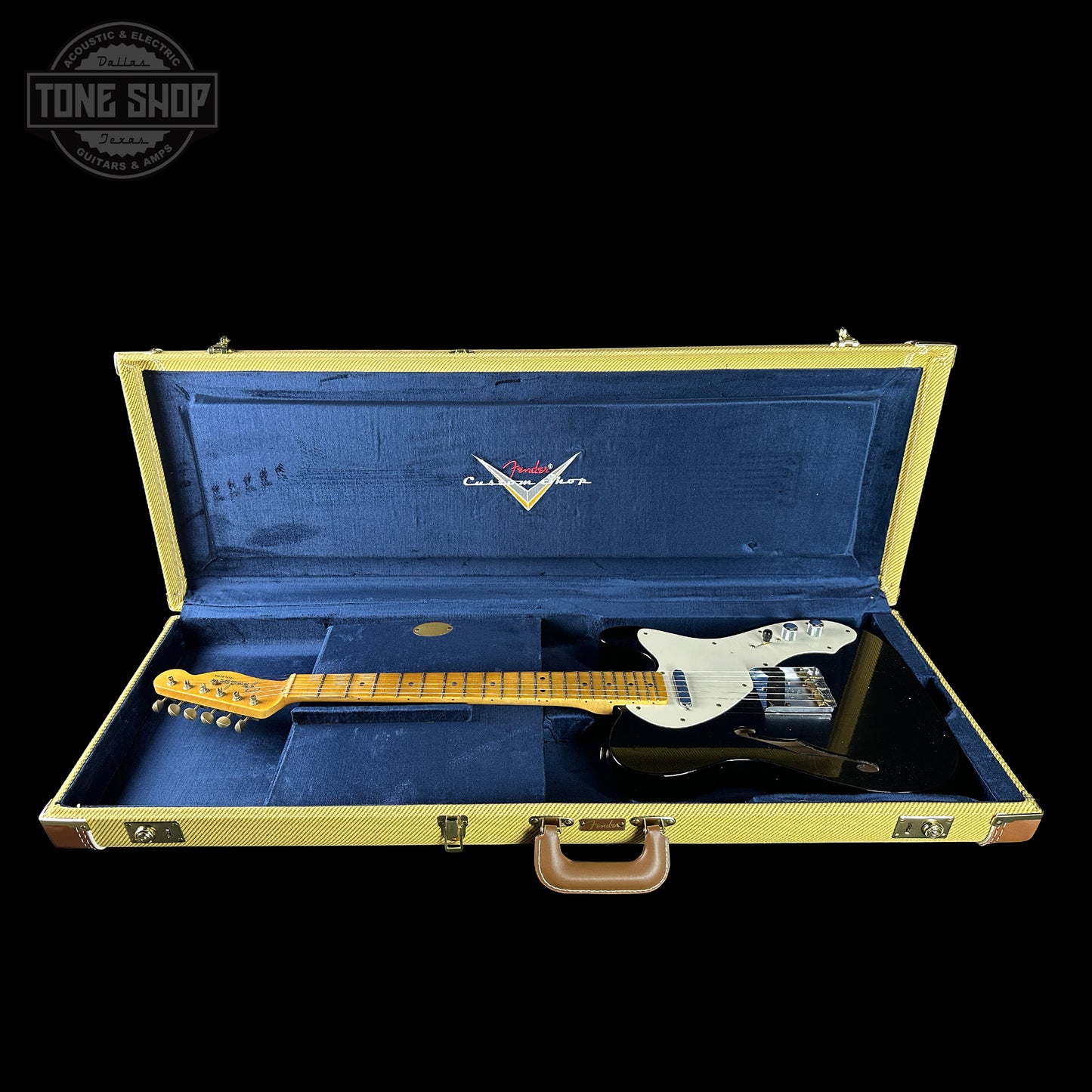 Fender electric guitar in a blue case with 'Tone Shop' logo.