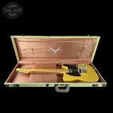 Yellow electric guitar in a wooden case with Fender logo, Tone Shop branding.