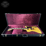 Yellow electric guitar in a purple-lined case with 'Tone Shop' logo.