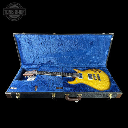 Electric guitar in a blue-lined case with 'Tone Shop' logo.