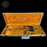 Guitar in an open case with 'Tone Shop' branding.