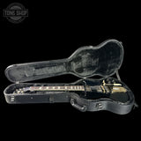 Guitar in a black case with 'Tone Shop' logo in the corner