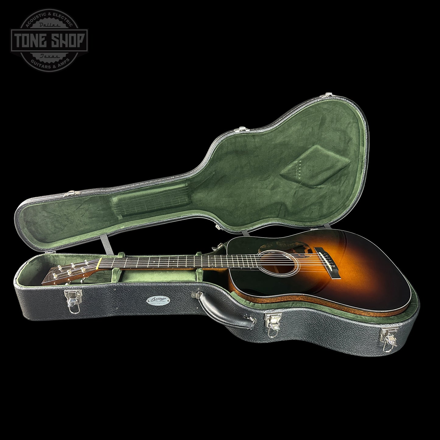 Acoustic guitar in a green hardshell case with 'Tone Shop' logo.