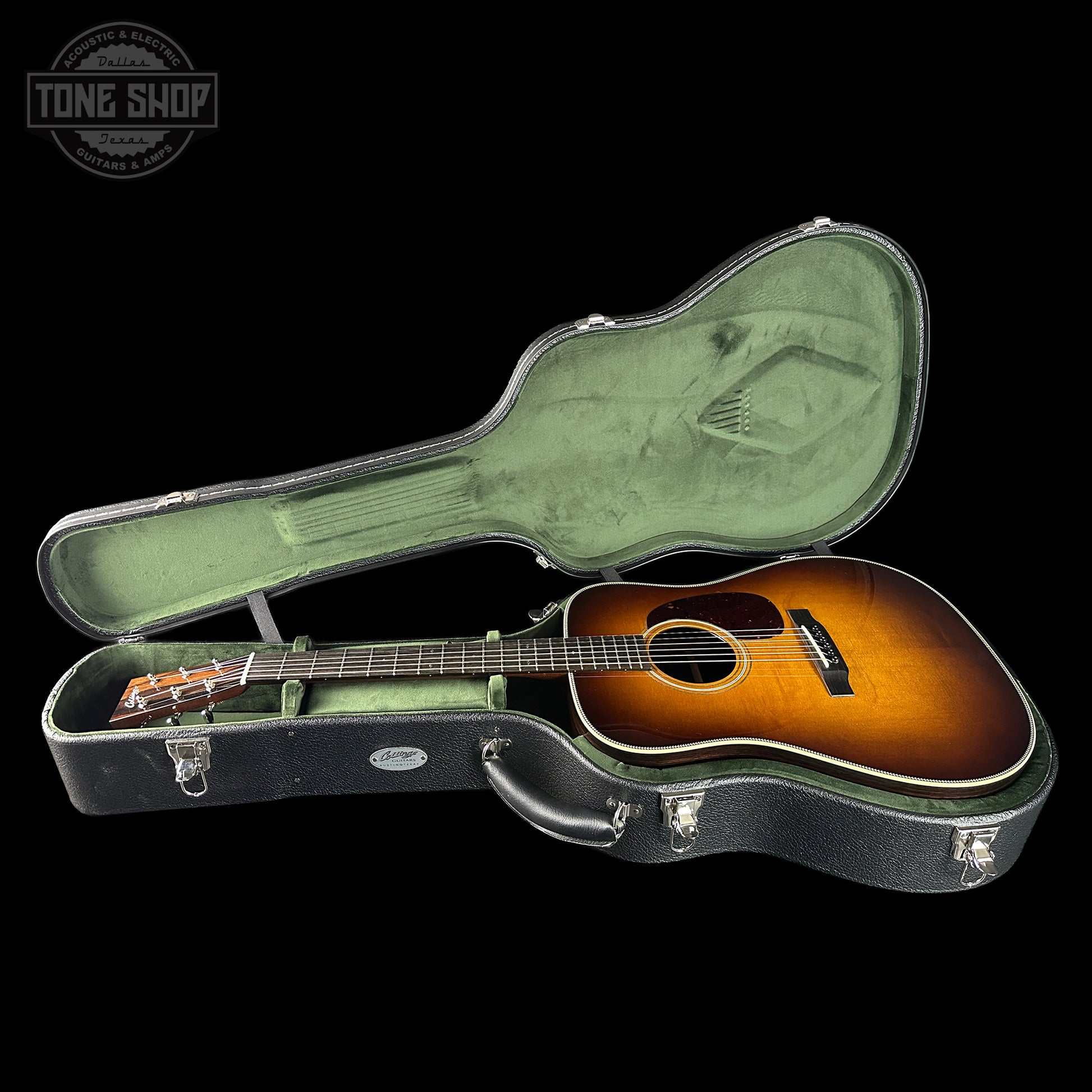Acoustic guitar in a hard-shell case with 'Tone Shop' logo.