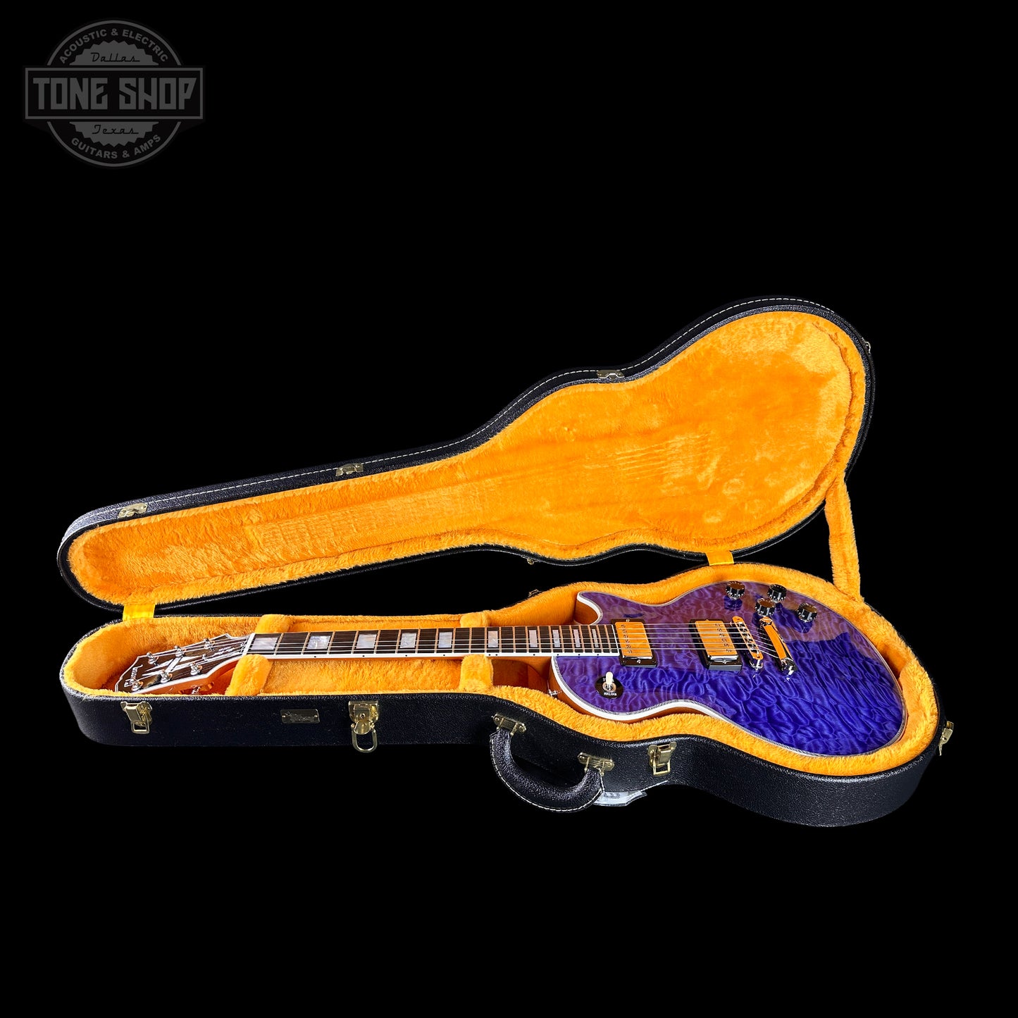 Electric guitar in an open case with a visible 'Tone Shop' logo.