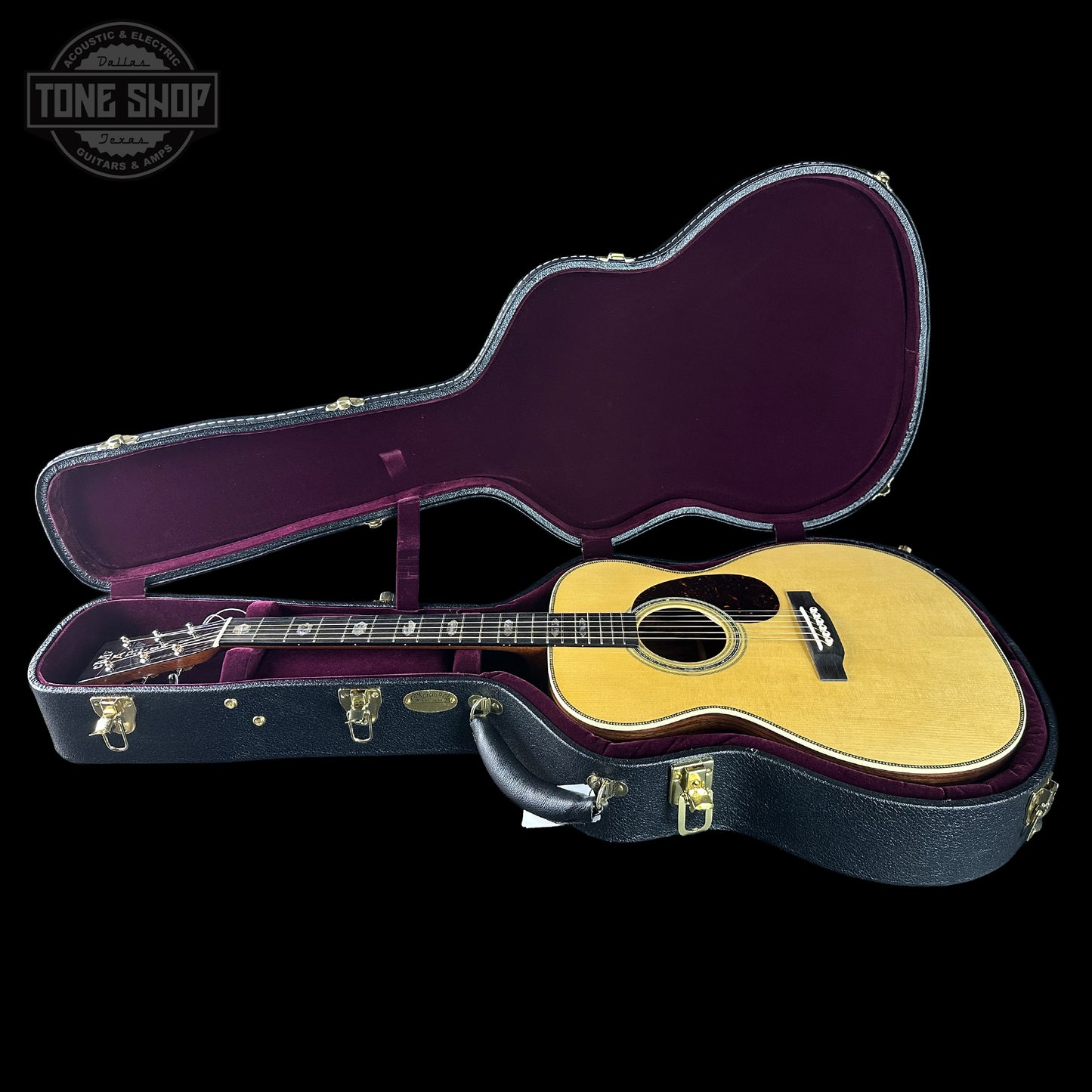 Acoustic guitar in an open guitar case with 'Tone Shop' logo.