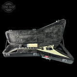 Jackson V guitar in a hard case with 'Tone Shop' logo.