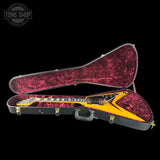 Glossy electric guitar in a maroon case with 'Tone Shop' logo.