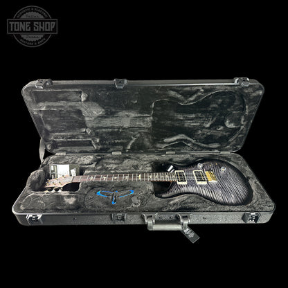 Guitar in a hard-shell case with 'Tone Shop' logo in the corner.