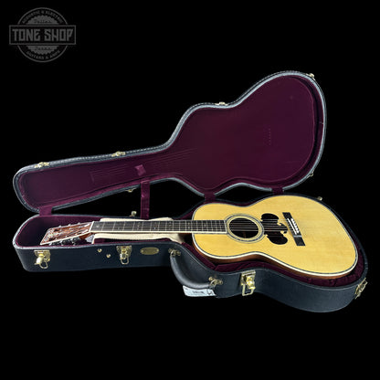 Acoustic guitar in an open guitar case with 'Tone Shop' logo.