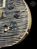 Close-up of a guitar's control knobs and headstock on a black background with 'Tone Shop' logo.
