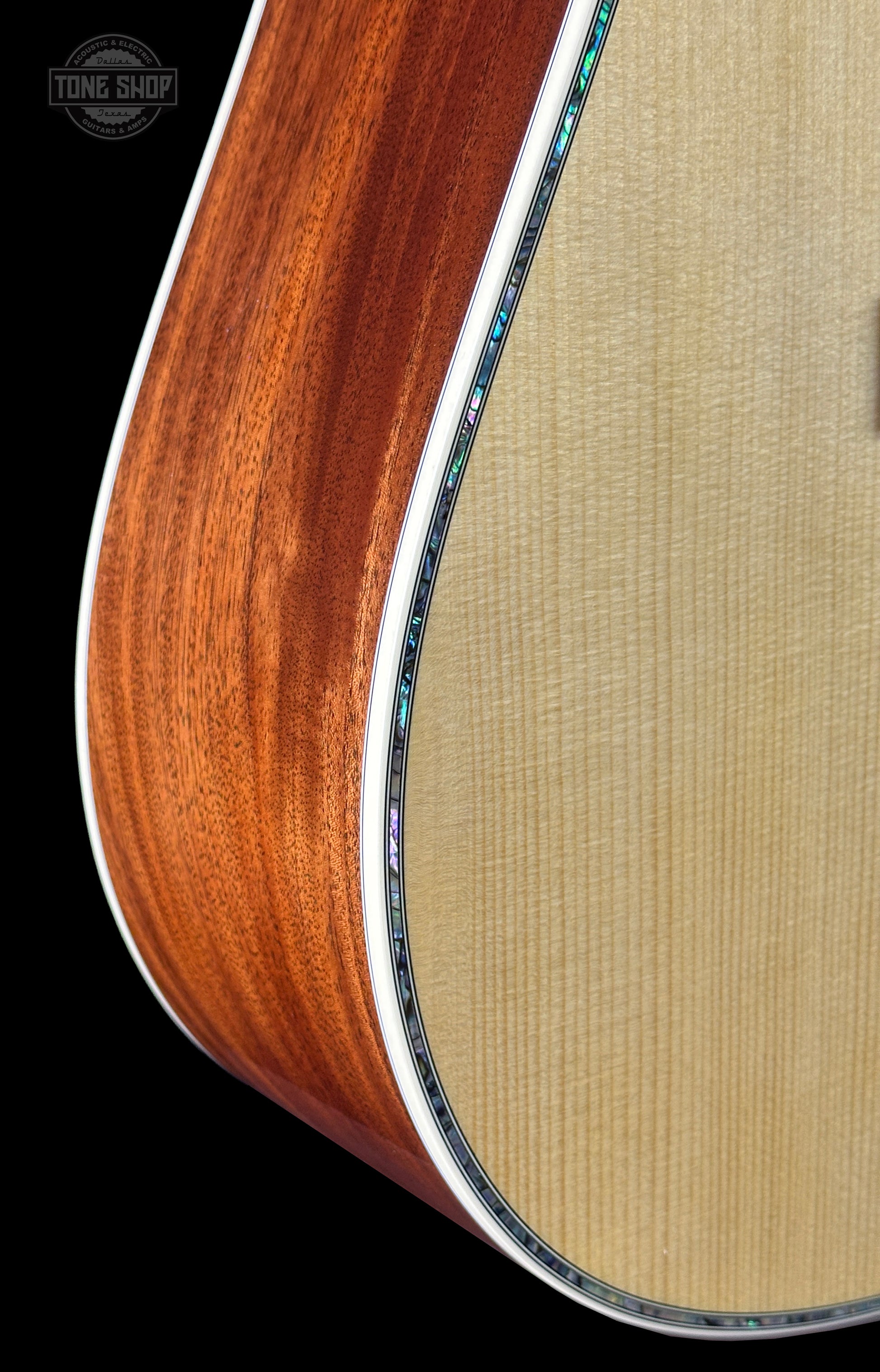 Close-up of a guitar's wooden finish with a visible brand logo.