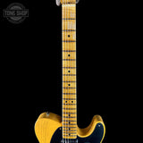 Electric guitar with a black and yellow design on a black background, featuring 'Tone Shop' branding.