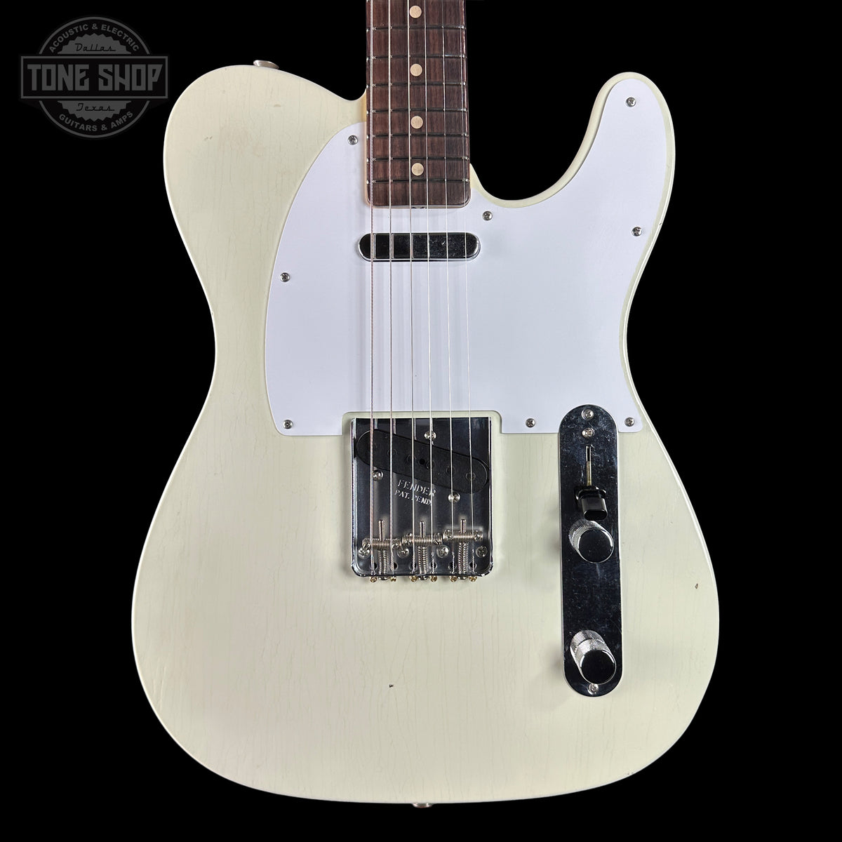 White electric guitar with a visible brand logo on a black background