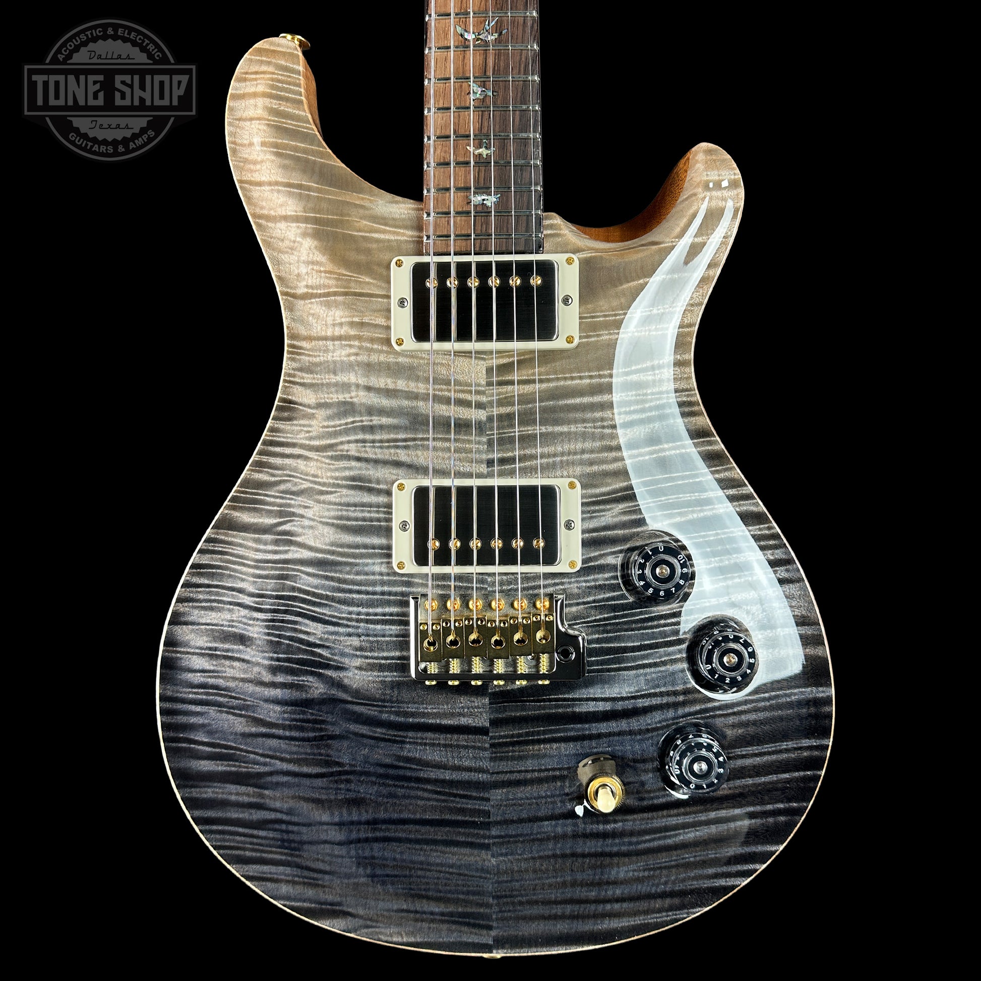 Electric guitar with a wavy wood finish on a black background, featuring the Tone Shop logo.