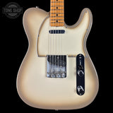 Electric guitar with a blonde finish on a black background, featuring the Tone Shop logo.
