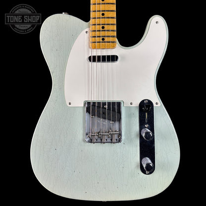 White electric guitar with a black pickguard on a black background, featuring 'Tone Shop' branding.