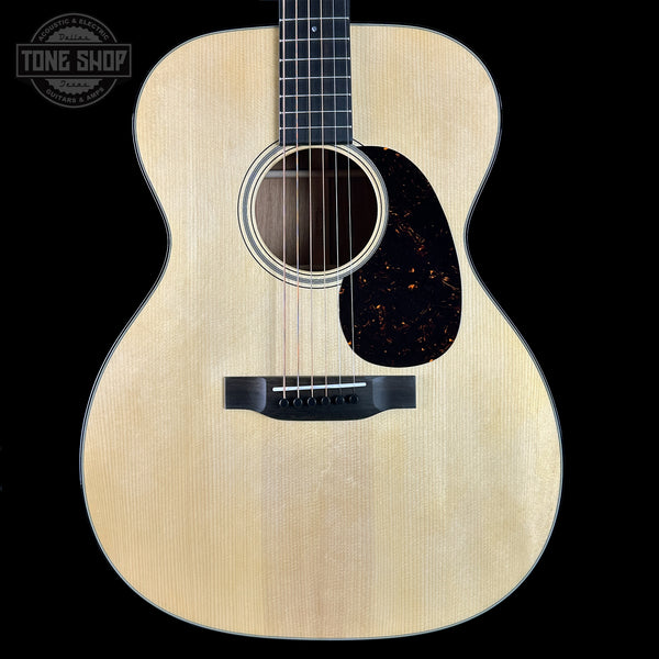 Acoustic guitar with a visible brand logo on a black background
