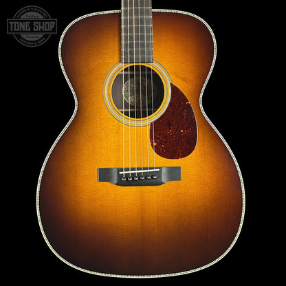 Acoustic guitar with a sunburst finish on a black background, featuring the Tone Shop logo.