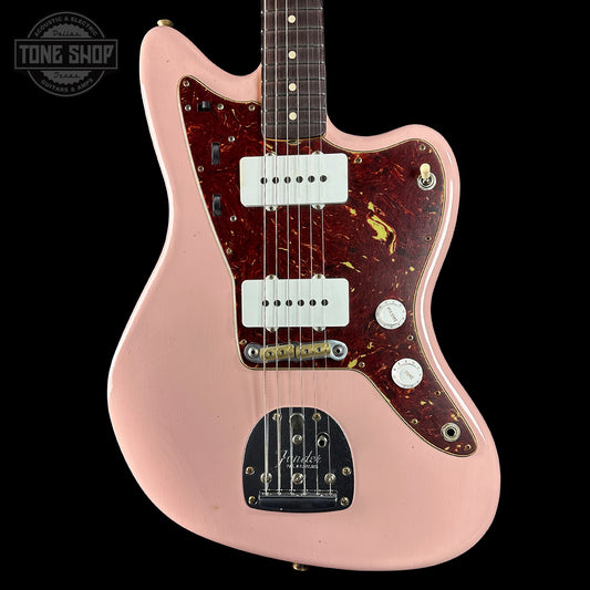 Pink electric guitar with a visible brand logo on a black background