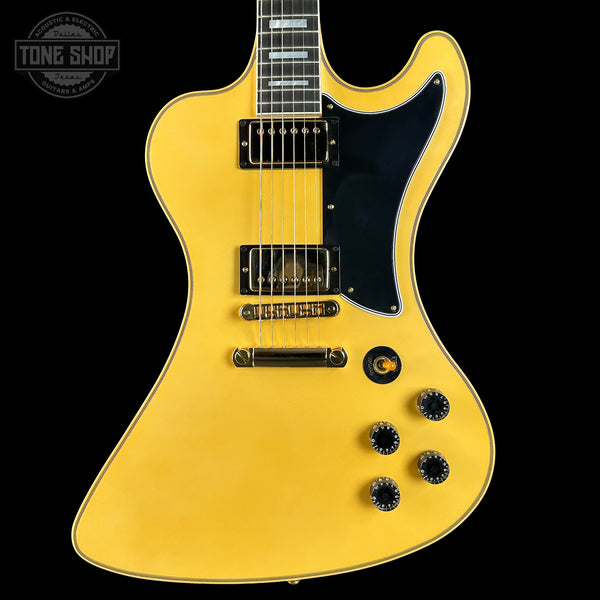 Yellow electric guitar with a black pickguard on a black background, featuring the Tone Shop logo.