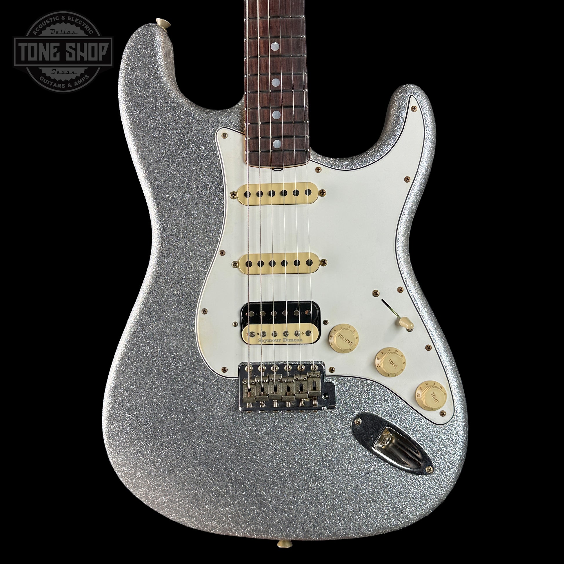Silver glitter electric guitar on a black background with 'Tone Shop' logo.
