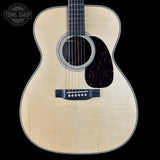 Acoustic guitar with a visible brand logo on a black background
