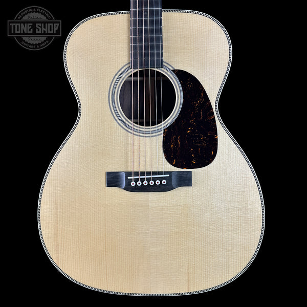 Acoustic guitar with a visible brand logo on a black background