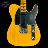 Yellow electric guitar with a black pickguard on a black background, featuring 'Tone Shop' logo.