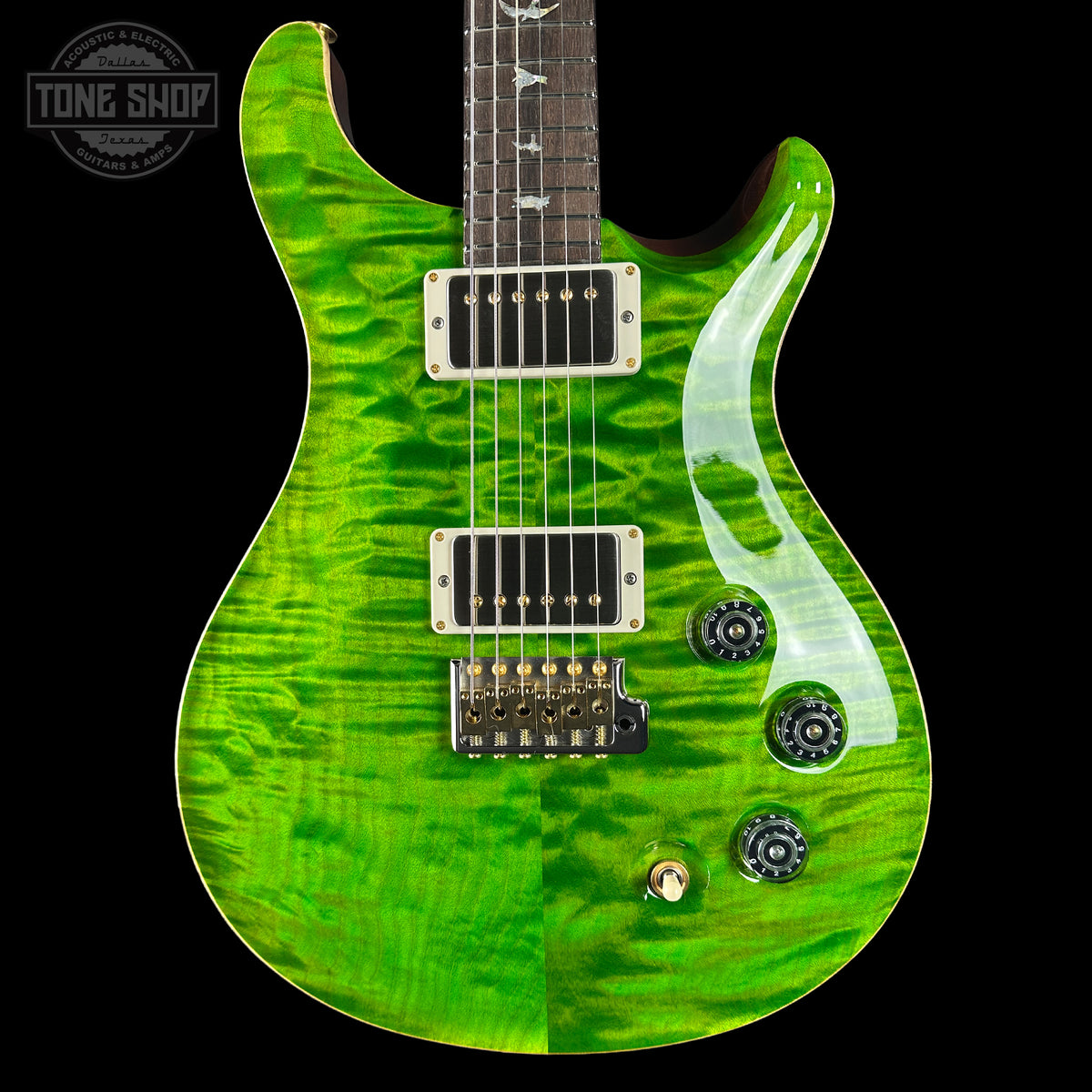 Green electric guitar with a black pickguard on a black background, featuring the Tone Shop logo.