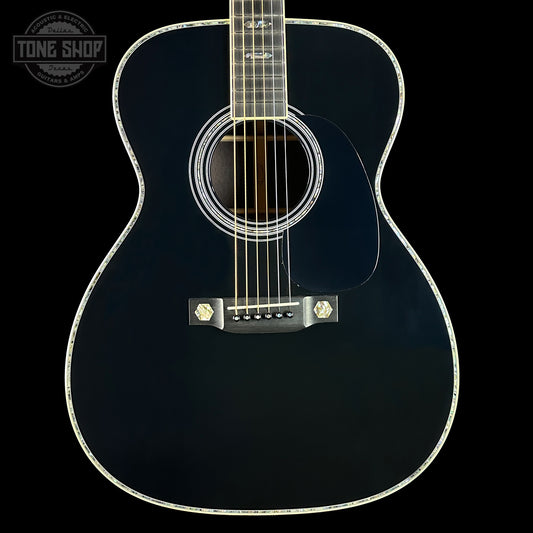 Black acoustic guitar on a black background with 'Tone Shop' logo.