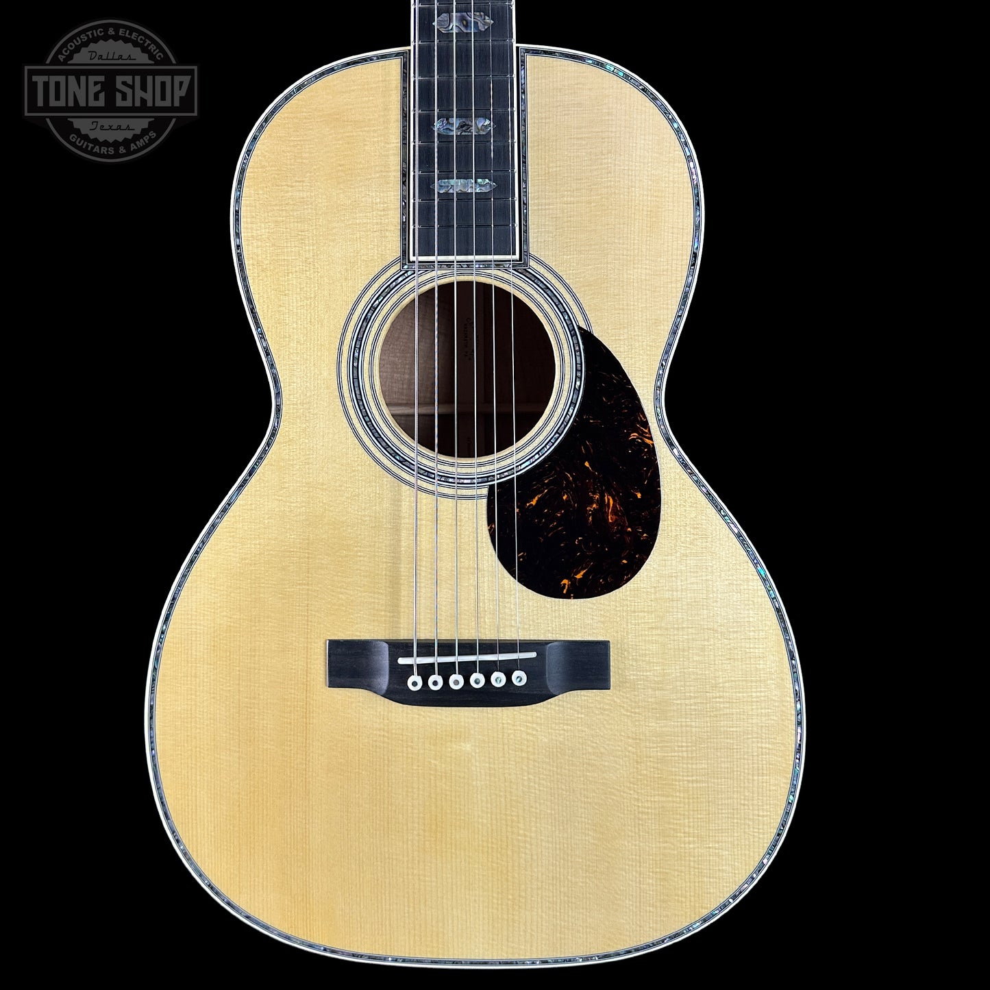 Acoustic guitar with a visible brand logo on a black background