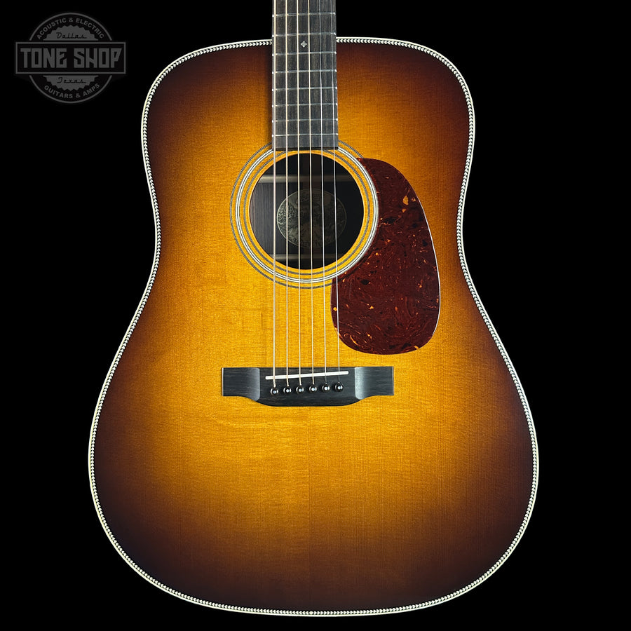 Acoustic guitar with a sunburst finish on a black background, featuring the Tone Shop logo.