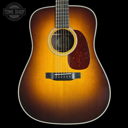 Acoustic guitar with a sunburst finish on a black background, featuring the Tone Shop logo.