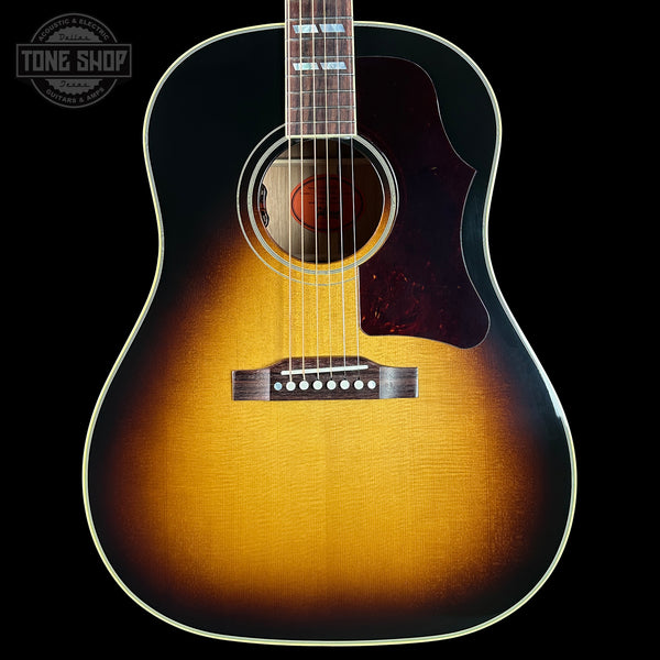 Acoustic guitar with a sunburst finish on a black background, featuring the Tone Shop logo.