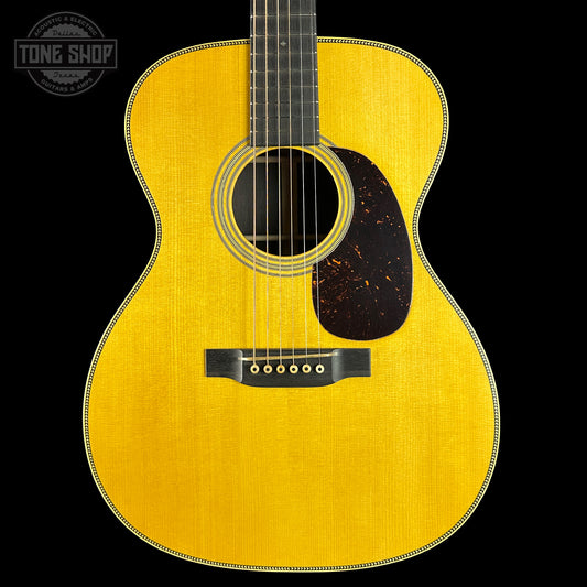 Acoustic guitar with a yellow finish on a black background, featuring the Tone Shop logo.