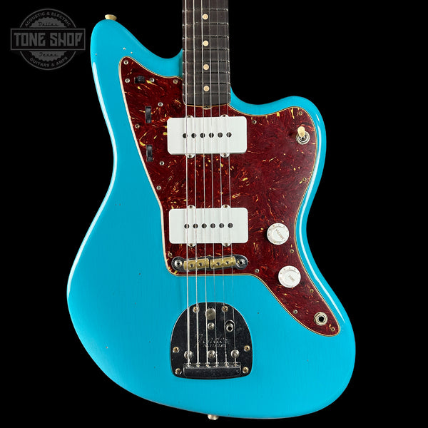 Blue electric guitar with a red pickguard on a black background, featuring 'Tone Shop' branding.