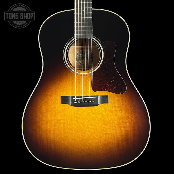 Acoustic guitar with a sunburst finish on a black background, featuring the Tone Shop logo.