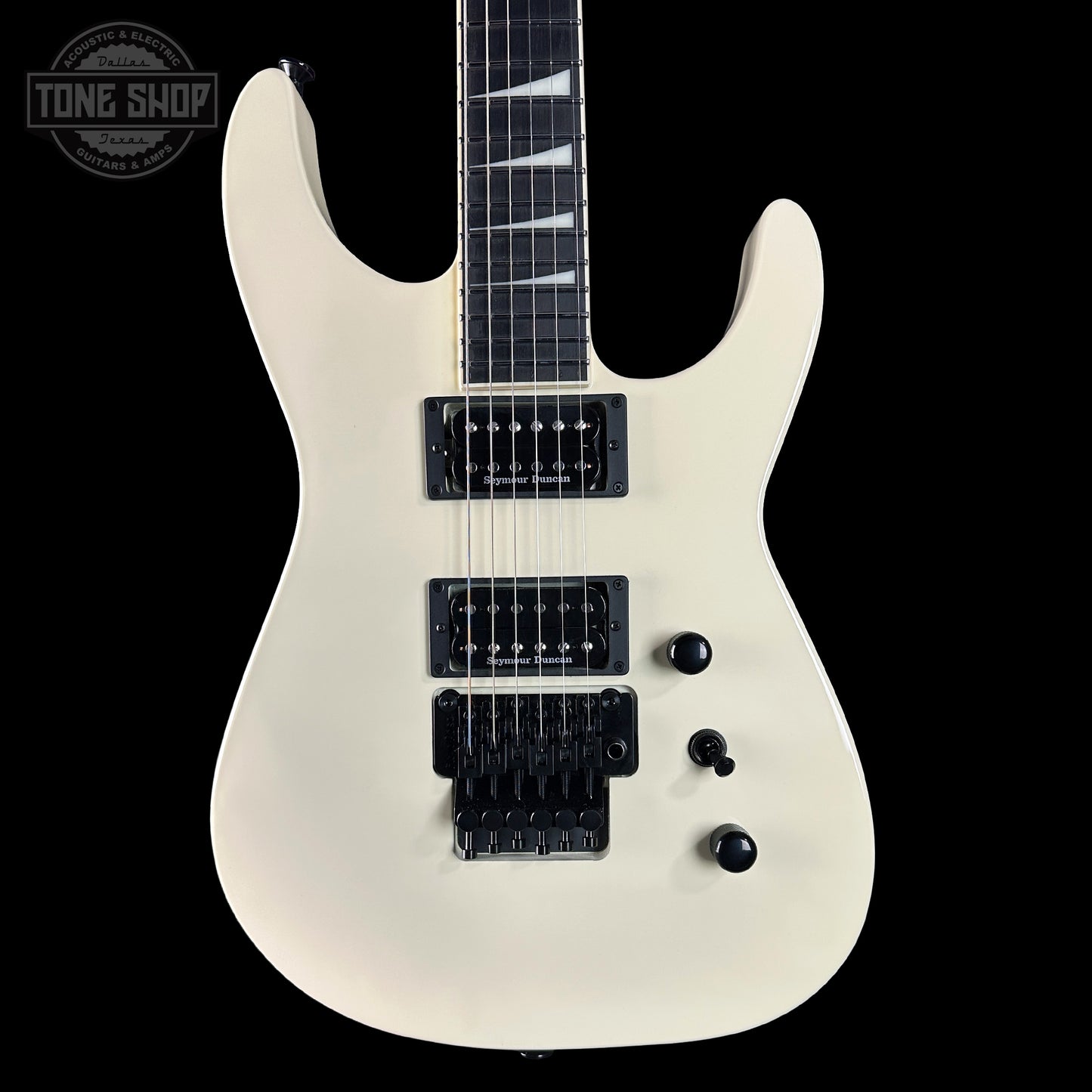 White electric guitar with black hardware on a black background, featuring 'Tone Shop' branding.
