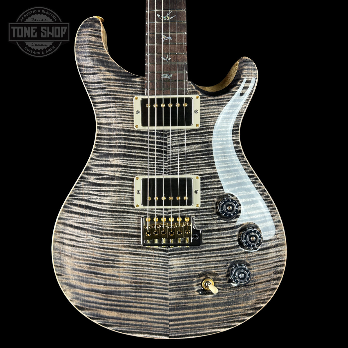 Electric guitar with a wavy wood finish on a black background, featuring the Tone Shop logo.