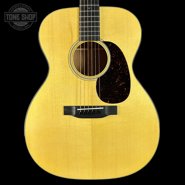 Acoustic guitar with a visible brand logo on a black background